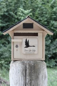 a wooden bird house on top of a tree stump at Swiss Lake Lodge in Noville