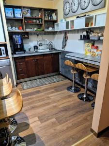 a kitchen with wooden floors and a counter with stools at Gina B&B in Rome