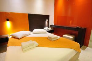 a bedroom with two beds with towels on them at Louloudis Fresh-Adults Only in Skala Rachoniou