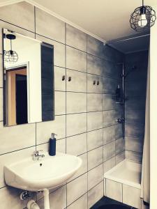Un baño con lavabo, espejo y bañera. en Artisan House Meraki, en Udbina