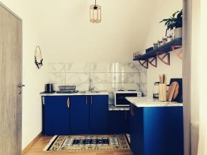 a kitchen with blue cabinets and a white counter top at Artisan House Meraki in Udbina