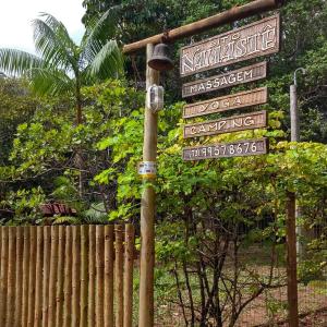 uma luz de rua com sinais ao lado de uma cerca em Sitio Namaste em Itacaré