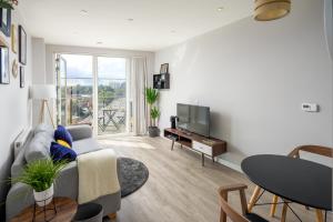 a living room with a couch and a television at Vertex Luxury Suite in Croydon