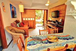 a living room with a table and a dining room at Pousada Vila Boa Vida in Bombinhas