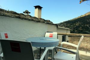 a blue table and chairs on a balcony at Casa Pampaneira 3 Hab 2 baños Terraza+Chimenea in Pampaneira