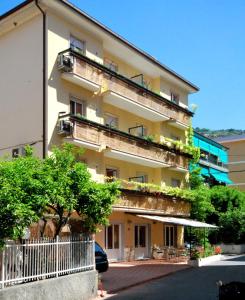- un grand bâtiment avec un balcon et des plantes dans l'établissement Residence Glicini, à Finale Ligure