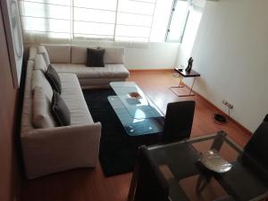 sala de estar con sofá blanco y mesa en Apart Peru, en Lima