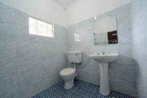 Un baño con inodoro, lavabo y espejo. en Swelanka Residence, en Bentota