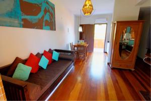 a living room with a couch with colorful pillows at Pousada Vila Boa Vida in Bombinhas