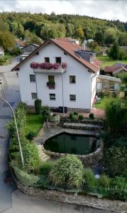 ein Haus mit einem Teich davor in der Unterkunft Ferienwohnung Uschkereit in Waldmünchen