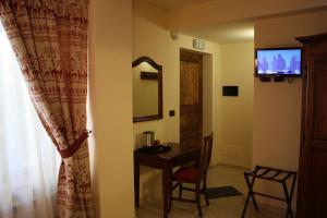 een kamer met een tafel, een spiegel en een televisie bij Olympic Mountains in Cesana Torinese