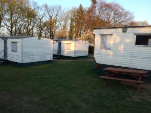 three mobile homes in a yard with a picnic table at Domki obok plaży in Moryń