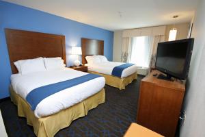 a hotel room with two beds and a flat screen tv at Holiday Inn Express Hotel & Suites Terre Haute, an IHG Hotel in Terre Haute
