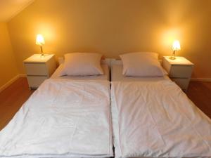 a bedroom with two beds with white sheets and two lamps at Pokoje gościnne Barka in Wadowice