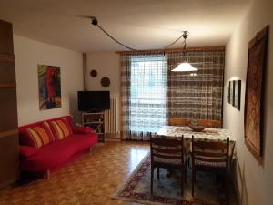 ein Wohnzimmer mit einem roten Sofa und einem Tisch in der Unterkunft Haus Anderl in Maria Alm am Steinernen Meer
