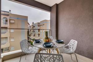 a balcony with a table and chairs and a window at Apartamento Pinada Beach- La Mata in La Mata