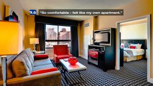 a hotel room with a couch and a tv and a bed at Deluxe Union Square Suites in San Francisco