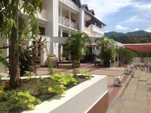 a building with a courtyard with trees and plants at Hotel Normandie Limited in Port-of-Spain