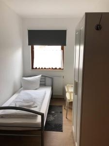 a small bedroom with a bed and a window at Pension ,,Vier Tore'' in Neubrandenburg
