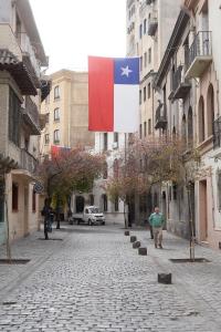 eine Flagge, die über einer Straße in einer Stadt weht in der Unterkunft Santiago WORLD in Santiago