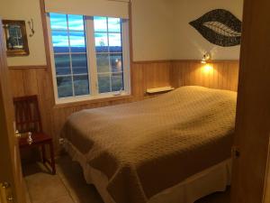 1 dormitorio con cama y ventana en Eyjasol Cottages en Reykholt