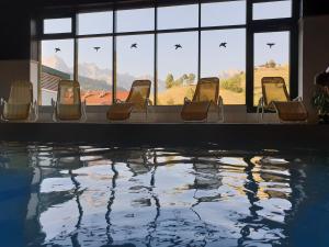 a group of chairs sitting next to a swimming pool at Haus Anderl in Maria Alm am Steinernen Meer