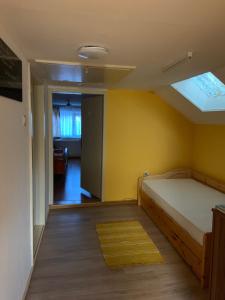 ein Schlafzimmer mit einem Bett und einer gelben Wand in der Unterkunft Serschenhof- Auszeit über dem Stall in Leutschach