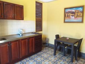 a kitchen with a table and a small table with a stool at Residencial La Fonte in Santo Domingo
