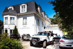 a white jeep parked in front of a building at Willa Alexander Resort & SPA - caloroczny BASEN kryty, szybkie Wifi! in Mielno