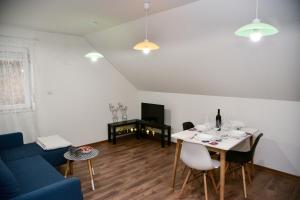a living room with a table and a blue couch at Tesla Coil Apartments in Gospić