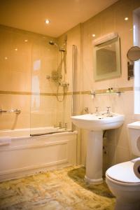a bathroom with a sink and a shower and a toilet at Beverley Hotel in Walsall