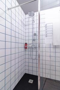 a bathroom with a shower with white tiled walls at Apartamentos Navío in Valencia