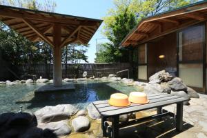 a pool with a picnic table with two hats on it at Minshuku Miyama in Yamanouchi