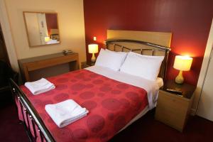 Un pat sau paturi într-o cameră la Clifton Hotel