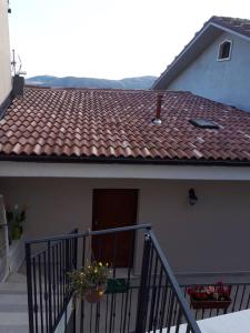 una casa con tetto piastrellato e balcone. di Appartamenti Raggio di Sole a Castel del Monte