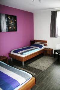 a bedroom with two beds and a purple wall at AdBurg-Hom in Homburg