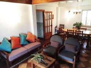 sala de estar con sofá, sillas y mesa en Finca Artienza en Ramales de la Victoria