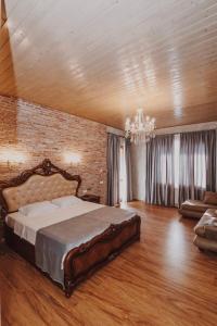 a bedroom with a large bed and a brick wall at Galaktioni's Marani in Kondoli