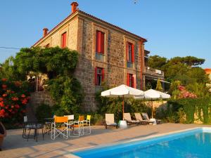 米西姆纳Molyvos Manor的一座带游泳池、椅子和遮阳伞的房子