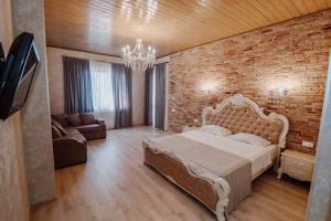 a bedroom with a large bed and a brick wall at Galaktioni's Marani in Kondoli