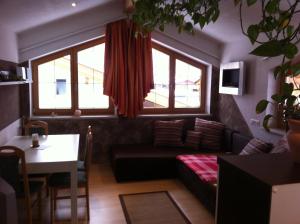 a living room with a couch and a table and windows at Haus Schiestl in Zell am Ziller