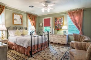1 dormitorio con 1 cama y 1 silla en The Stockade Bed and Breakfast, en Baton Rouge