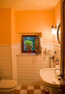 a bathroom with a sink and a toilet and a window at Finca Artienza in Ramales de la Victoria