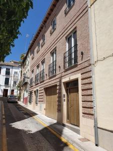 een bakstenen gebouw met twee garagedeuren in een straat bij ecoSmart Apartments Granada in Granada