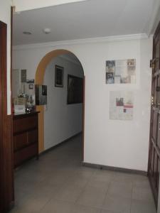un pasillo con un arco y una pared blanca en Hostal Pan America, en Madrid
