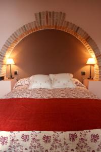 CarenasにあるCasa Rural Los Pedregalesのベッドルーム1室(大型ベッド1台、ランプ2つ付)