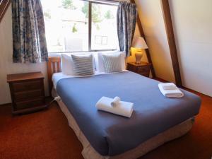 a bedroom with a bed with two towels on it at Arosa - Lake Tekapo in Lake Tekapo