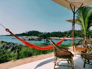 a hammock on a patio with a view of the ocean at Abidal Resort in Patnem