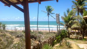 Blick auf einen Strand mit Palmen und das Meer in der Unterkunft Casa ImBale in Imbassai