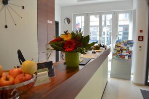 a kitchen counter with a vase of flowers on it at Augusten Hotel München in Munich